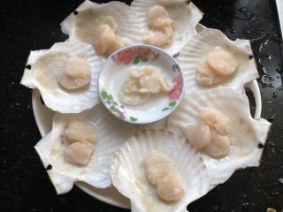 粉丝蒸扇贝,总刀把扇贝破开,沿着壳壁小心的取下贝肉,去掉内脏和腮,留下壳肉和月牙形的黄(我们家不喜欢,我全给扔掉了),把贝肉分到贝壳上。