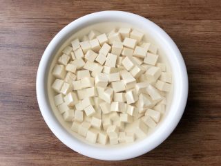 青菜豆腐汤,豆腐冲洗一下,切成小方块,放入碗里,加入一勺盐,适量清水浸泡半个小时,浸泡好冲洗干净,沥干水待用。