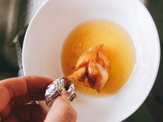 蜜汁烤翅根-年夜饭、宴请菜类,准备适量蜂蜜,将每一根翅根逐个放到蜂蜜里滚一圈,全部裹上蜂蜜。