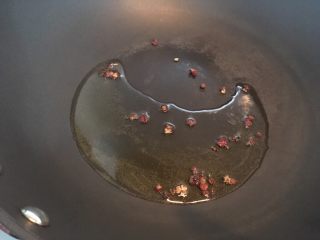 酸汤金针肥牛,热锅热油放入花椒炒香后,把花椒捞出。