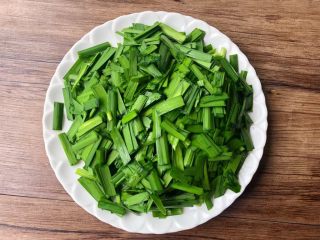 豆芽炒韭菜,韭菜摘掉黄色的叶子,清洗干净切成段,装入盘里待用。