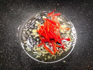 豆芽炒韭菜,锅里放入适量油烧热,放入姜末炒香,再放入红椒丝炒至断生。