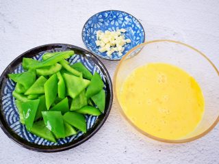 青椒炒鸡蛋,青椒去蒂去籽洗净切成小块,鸡蛋搅打均匀备用,蒜切末