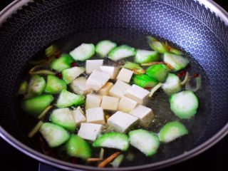 丝瓜花蛤炖豆腐,大火煮沸后,放入焯水的豆腐。