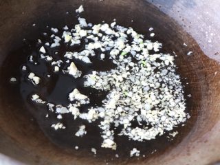 蒜苔炒腊肠,锅内放适量色拉油,放蒜末炒香;