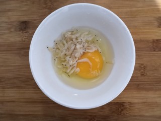 番茄丝瓜补钙粥,把鸡蛋磕入碗中,放入虾米,盐