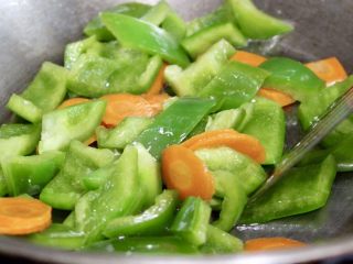 青椒炒肉,留原锅油,放入青椒和胡萝卜片翻炒至8分熟,中途可以适当加少许清水