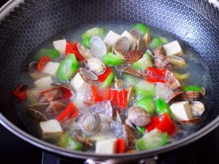 丝瓜花蛤炖豆腐,加入红椒丝,大火继续煮沸。