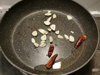 爆炒豆角,炒锅放入食用油 加热 放入蒜片和干辣椒 翻炒出香味