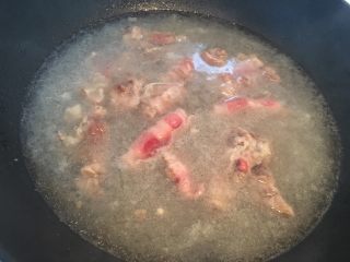酸汤金针肥牛,锅中加水、姜片和料酒烧开后关火,把肥牛放入锅中烫半分钟。